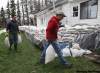 JOE BRYKSA/WINNIPEG FREE PRESS-
Ted  Bray, right, and his son John do last-minute  sandbagging at  their home near Oakville. Their home is next to the Elm River.