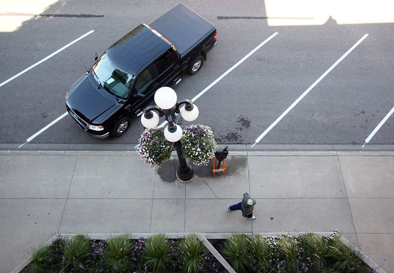 Tim Smith/Brandon Sun
A pedestrian walks past a vehicle parked in the new angle parking on Ninth Street on Wednesday.
