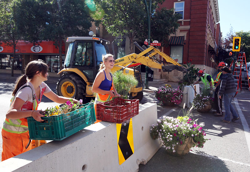 Tim Smith/Brandon Sun
City of Brandon workers install potted plants and flower baskets on Rosser Avenue between Ninth and 10th streets on Wednesday morning as the downtown pedestrian mall is prepared to be opened to the public.