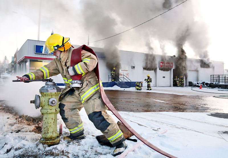 Colin Corneau/The Brandon Sun
Firefighters work to contain a blaze at the Sturgeon Tire building at First Street and Pacific Avenue late Monday afternoon.