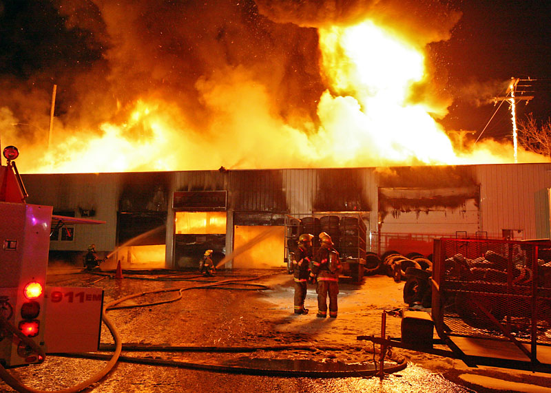 Colin Corneau/Brandon Sun
Flames leap from the Sturgeon Tire building during a blaze Monday evening at the corner of First Street and Pacific Avenue.