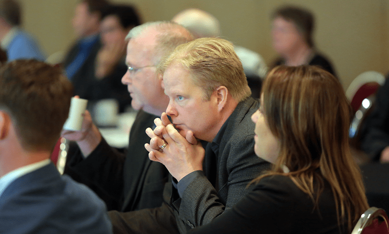 Bruce Bumstead/ Brandon Sun
Brandon Chamber of Commerce president Todd Birkhan, middle, reviews amendments during the Manitoba Chambers of Commerce annual general meeting at the Victoria Inn on Sunday.