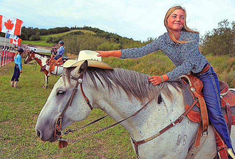 Colin Corneau/Brandon Sun
Hanna Popp puts her hat on her horse Gunner while awaiting her turn to compete in ladies barrel racing at the Minnedosa Rodeo on Saturday evening. The Erickson rider was one of the competitors in the Heartland Rodeo events.