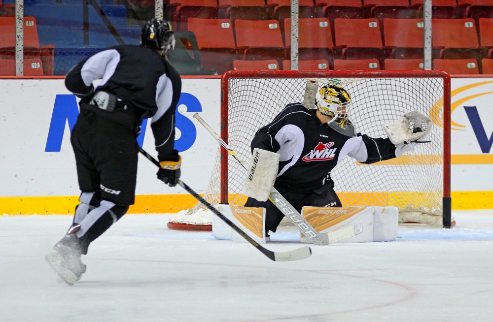 Brandon Wheat Kings goaltender Jordan Papirny watches the puck settle into his glove on a shot by Blake Jameson during practice on Thursday. (Perry Bergson/The Brandon Sun)
