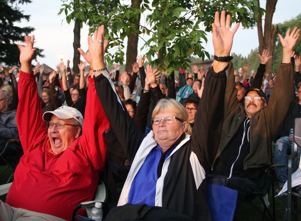 Mark Starodub of Selkirk, left, gets animated before the Doc Walker concert when the audience was asked to put their hands up. His wife, Charlene Fox, more reserved at this moment, plays along, too. The couple was among the thousands of people to take in the free concert at Riding Mountain National Park on Saturday evening.