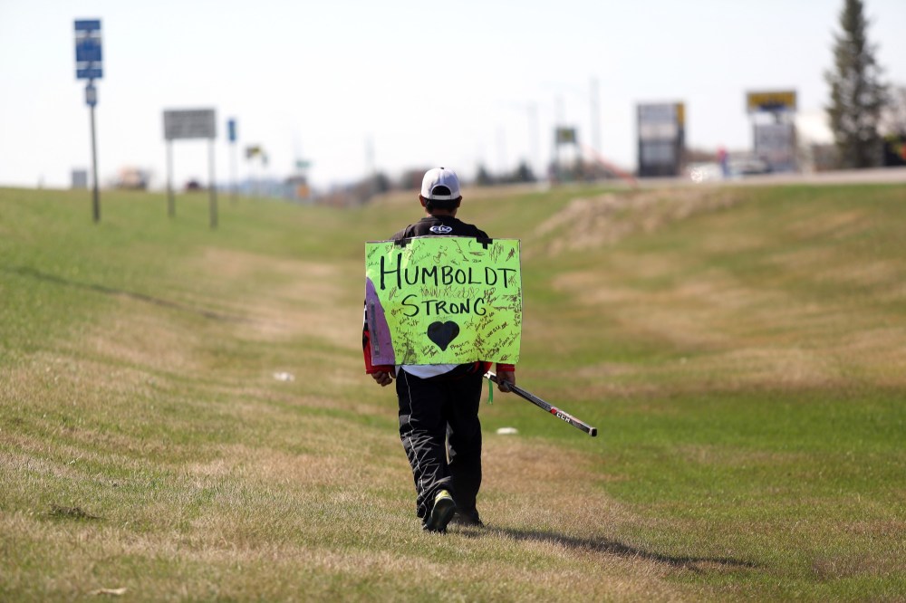 Michael Lee/The Brandon Sun
Rance Cardinal walks alongside 18th Street North on Sunday with a hockey stick in hand and his Humboldt Strong sign on his back.