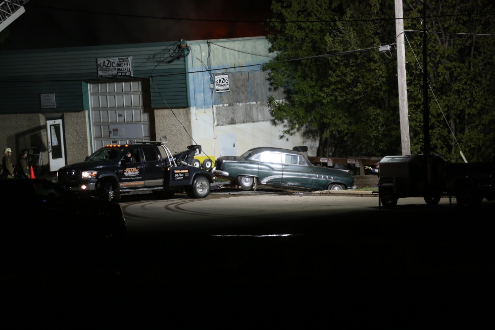 MICHAEL LEE/THE BRANDON SUN
A tow truck pulls a vehicle out from behind the Collyer's building on Pacific Avenue Saturday night as firefighters try to control an ongoing fire.