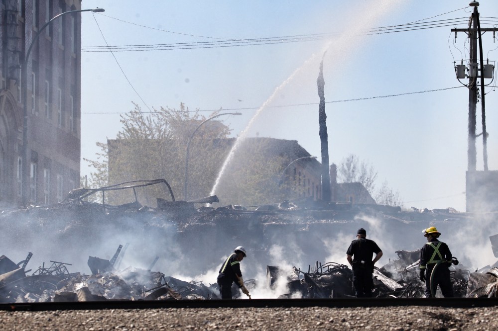 Matt Goerzen/The Brandon Sun
Firefighters and investigators with the Office of the Fire Commissioner sift through the rubble of the Christie's Office Plus building on Sunday morning.