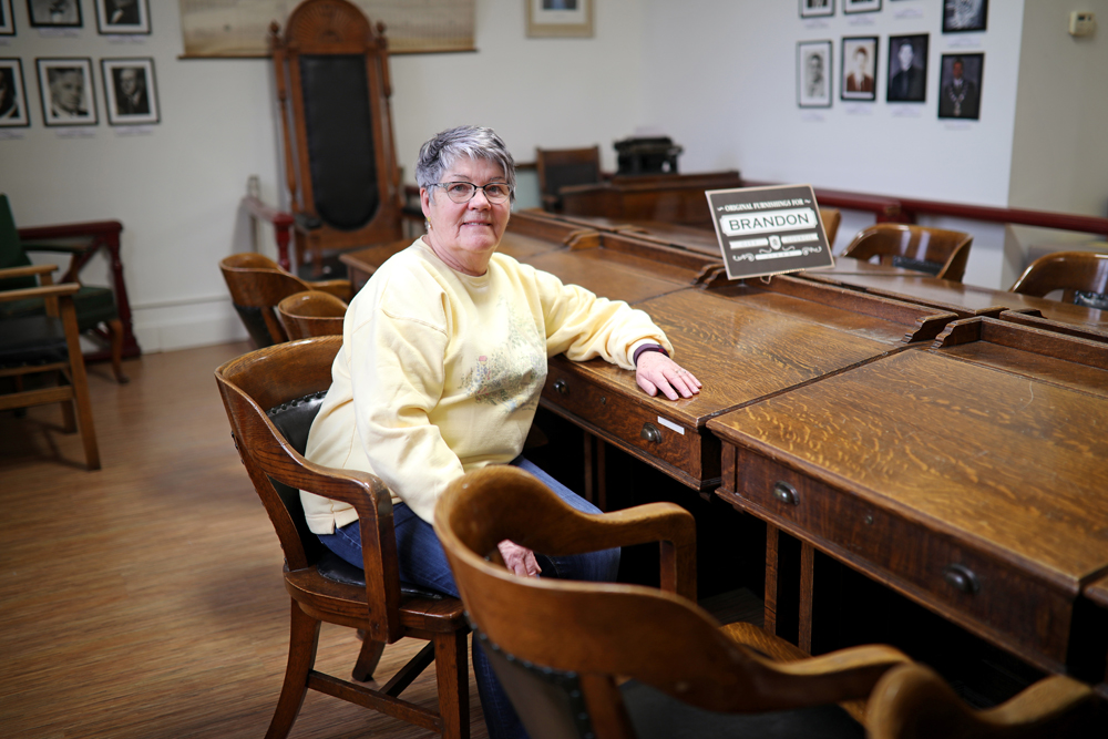Barb Andrew, board chair for the Brandon General Museum and Archives, pictured in January sits at the original furnishings for Brandon City Council, which is one of the exhibits on display at the museum's Ninth Street location. (Tim Smith/The Brandon Sun)