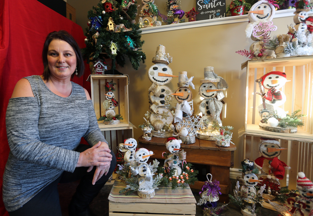 Kathy Friesen smiles beside the different snowmen she has created in her garage near Carberry. Friesen started up the business about four years ago. (Melissa Verge/The Brandon Sun)