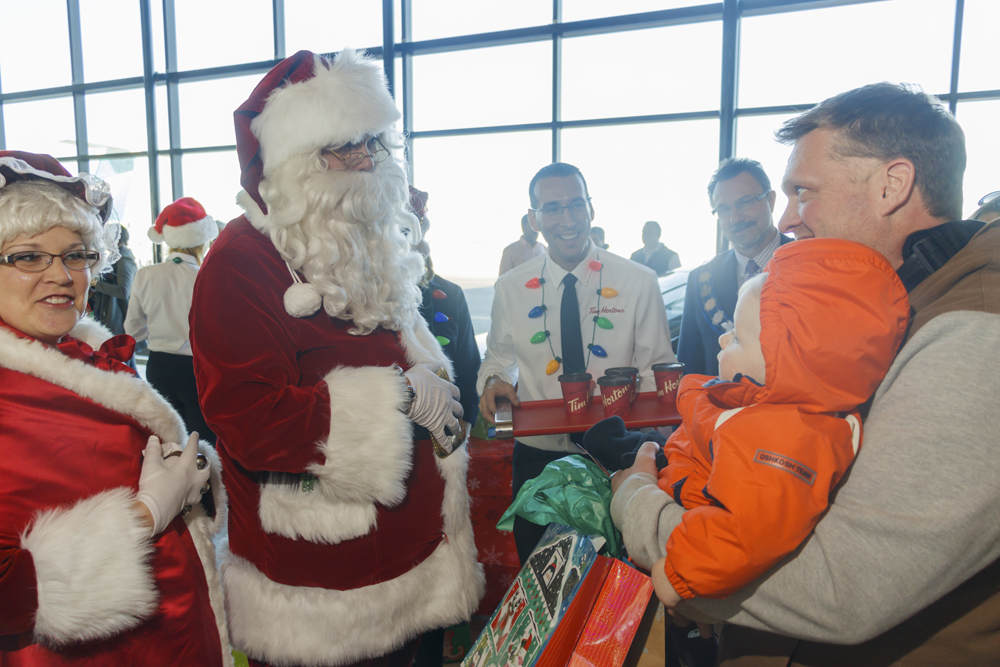 Mr. and Mrs. Claus greet Lee Allen Ruff and his son Mavryk, one, as they arrive at the Brandon Municipal Airport Friday. (Chelsea Kemp/The Brandon Sun)