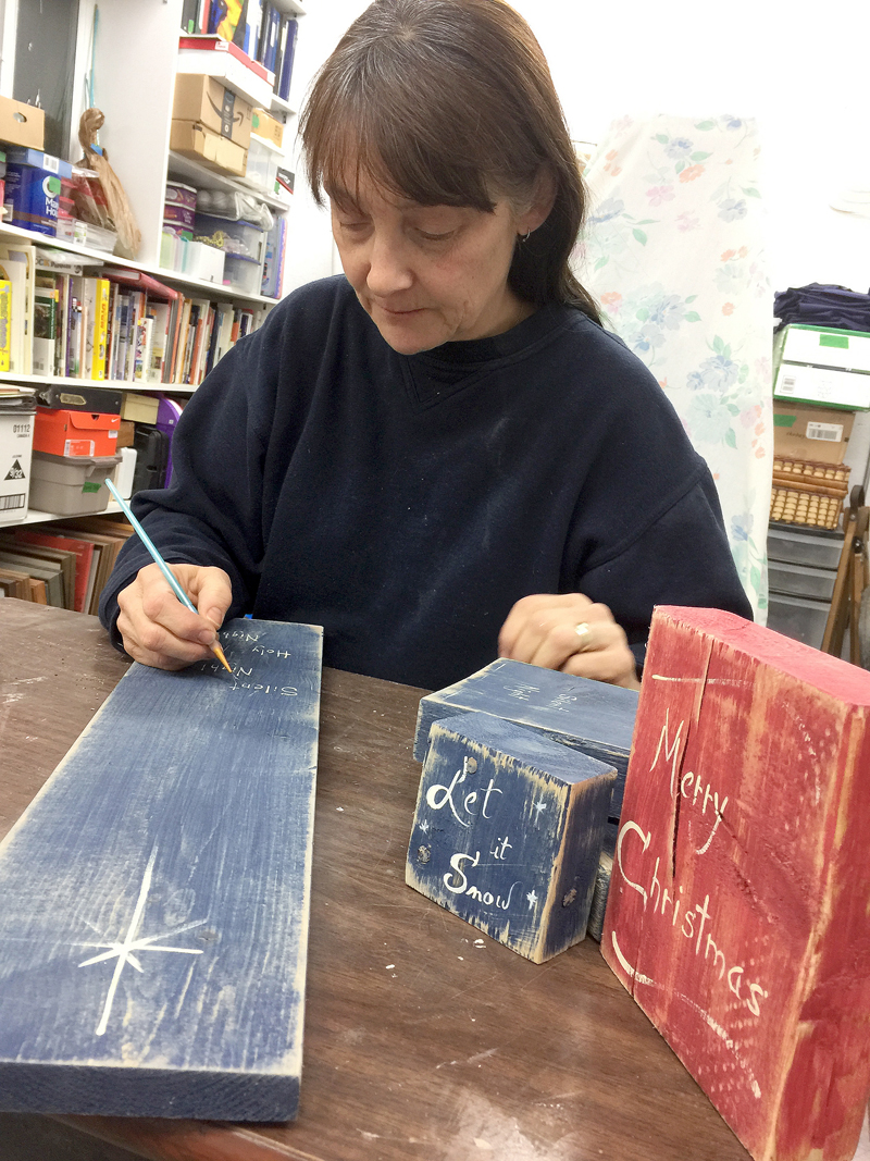 Tracey Currie works on one of her handmade signs. (Submitted)
