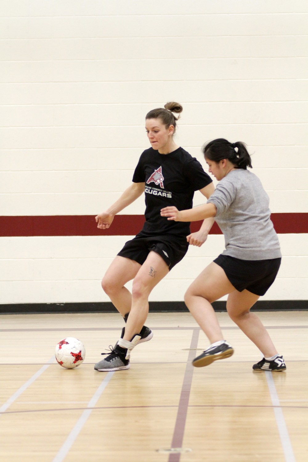 Jerra Green, left, shown defended by Kelly Cram during Assiniboine Community College Cougars futsal practice on Tuesday is ready for her first futsal season after finishing second in Manitoba Colleges Athletic Conference soccer scoring with 11 goals.
