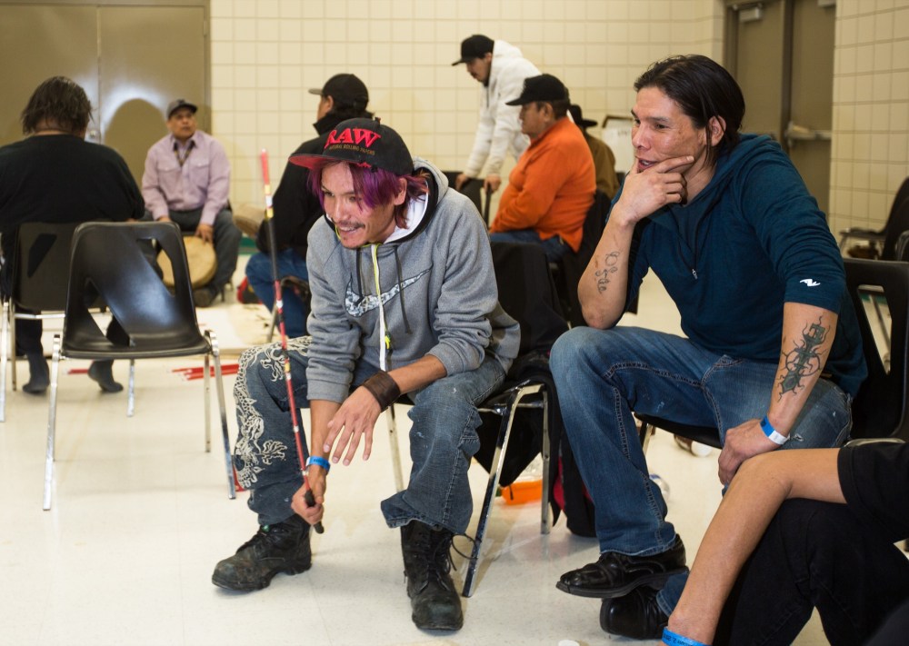Chelsea Kemp/The Brandon Sun
Dale Standing, left, Morgan Standing debate where an opponent has hidden the stone during a moccasin game on Saturday.