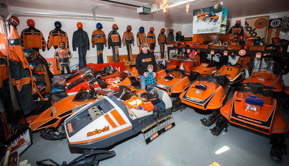 Darren Humphreys and his daughter Paisley, 6, pose for a photo in his Moto-Ski filled garage Friday. (Chelsea Kemp/The Brandon Sun)