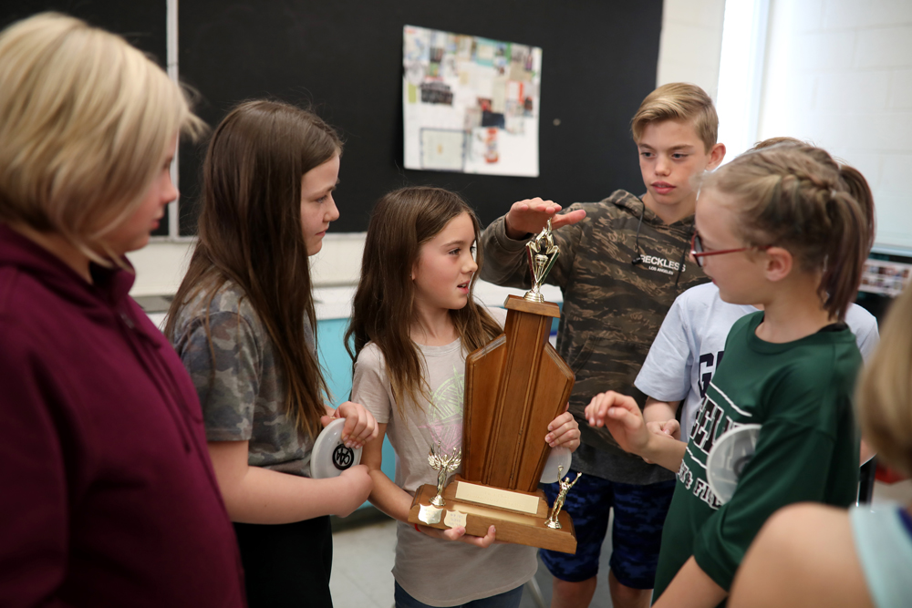 School patrollers from �cole New Era School get a close-up look at the trophy they received, held by Grade 5 student Abigail Cadegan-Syms, after winning the CAA Manitoba School Safety Patrol of the Year award for best school patrol in the city.  (Tim Smith/The Brandon Sun)