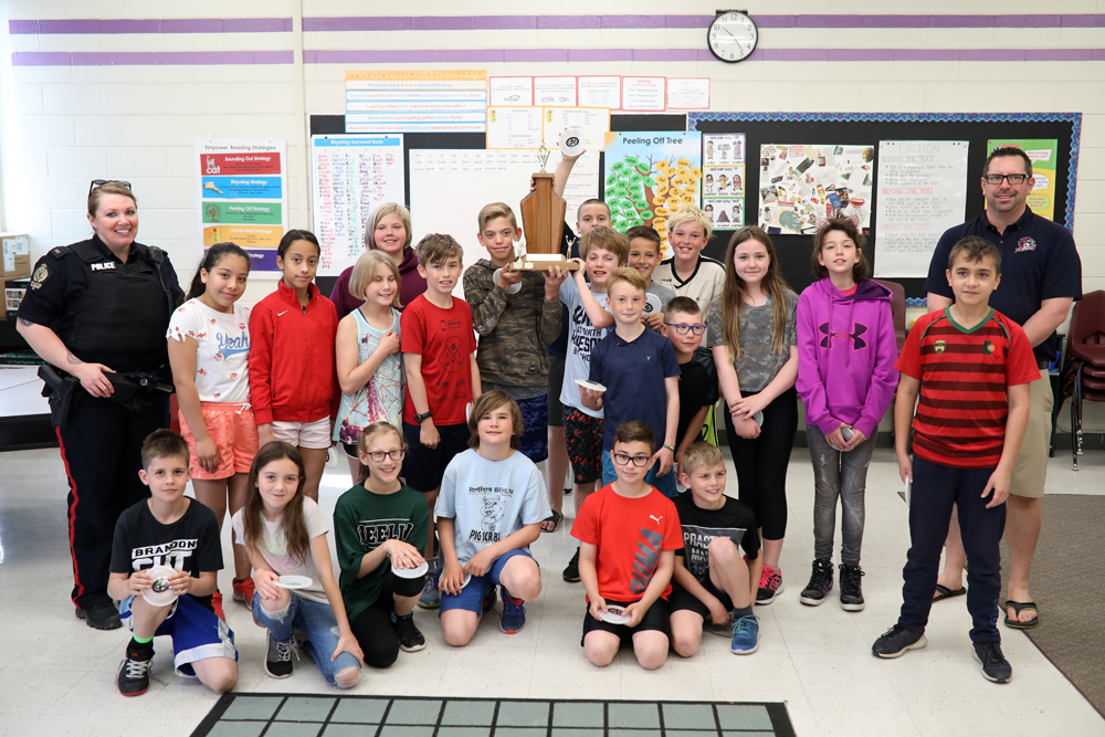 Brandon Police Service K-8 school resource officer Alice Potter and �cole New Era School vice-principal Curtis Gray (right) pose for a photo with the school's student patrollers after they won the CAA Manitoba School Safety Patrol of the Year award for best school patrol in the city.  (Tim Smith/The Brandon Sun)