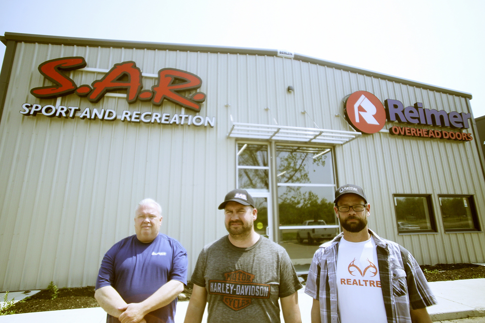 Owner Curtis Enns (centre), S.A.R. general manager Dave Gibson (left), and Reimer Overhead Doors branch manager Dave Gagnon (right) stand outside their soon-to-be-opened location at 1601 First St. (Colin Slark/The Brandon Sun)