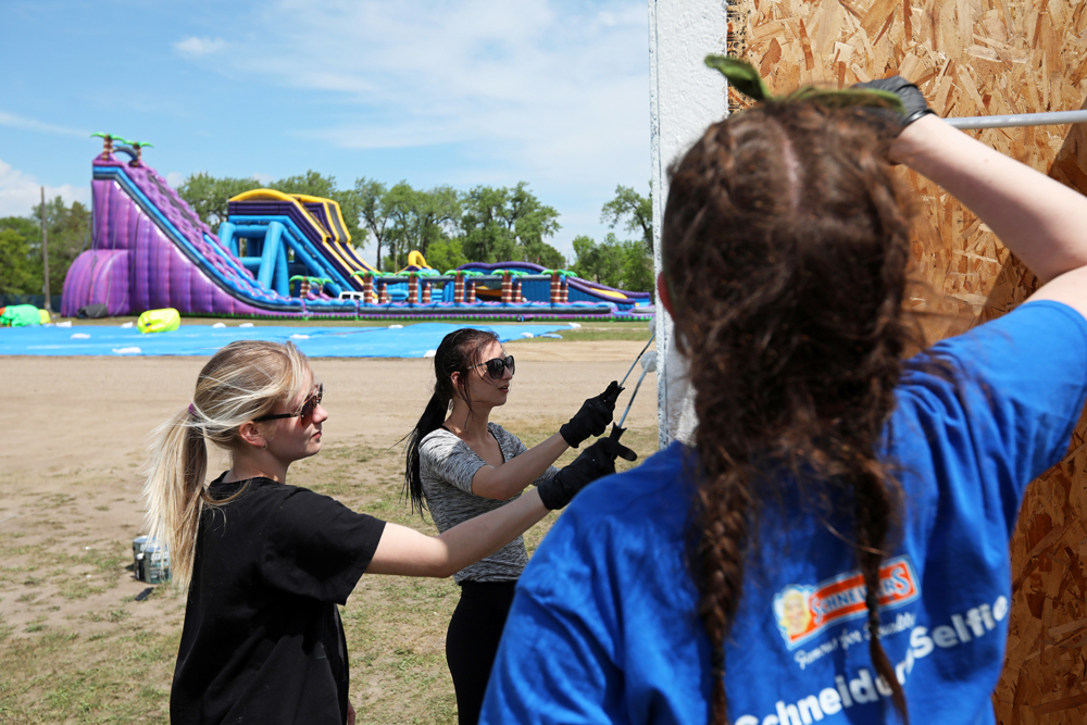 Oceanna Michel, Marisa Berkshire and Emily Hull paint a set of change rooms during set-up for the Brandon Bouncy Castles summertime water park at the Keystone Centre grounds on Tuesday afternoon.  (Tim Smith/The Brandon Sun)