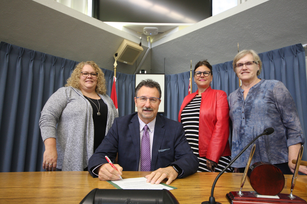 Learning Disabilities Association of Manitoba Brandon chapter board member Wendy Gross, executive director Shelly Brown and board member Sandra Puhach stand with Mayor Rick Chrest in Brandon City Hall council chambers. (Drew May/The Brandon Sun)