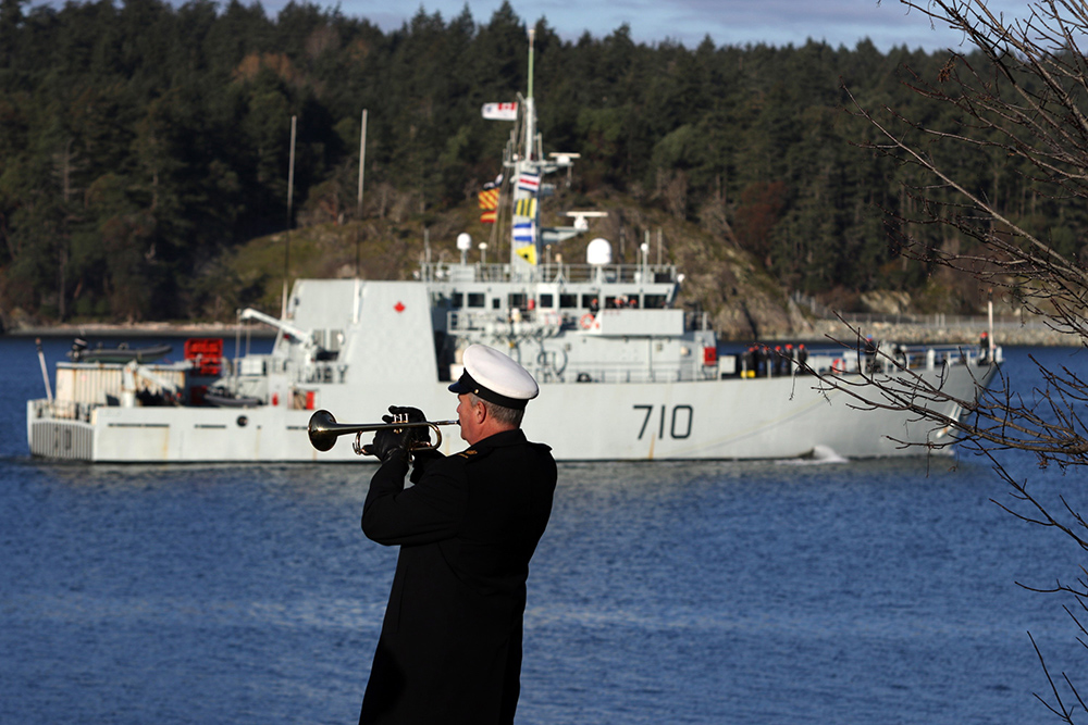 CP
Petty Officer Mike Broadley plays the bugle call as the crew from HMCS Brandon sails by at CFB Esquimalt in Esquimalt, B.C. in late 2016 following a six-week deployment on Operation CARIBBE where they seized a combined total of 2,820 kg of cocaine. (The Canadian Press)