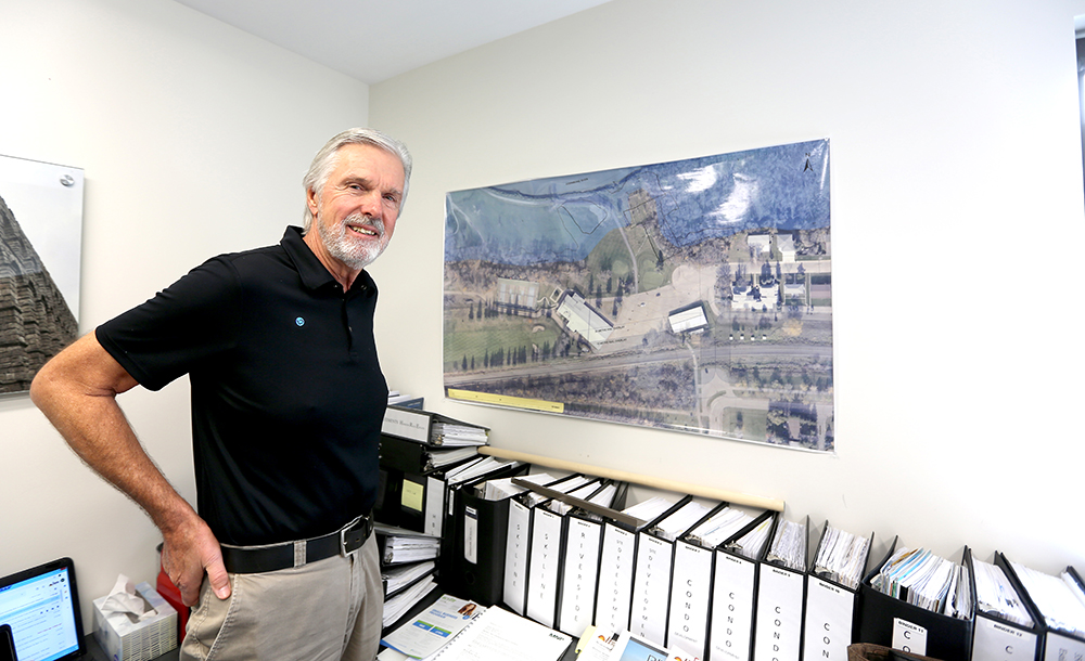 Project manager and president of Horizon Builders Ltd. Rod Lindenberg stands in front of an aerial photograph of the Wheat City Golf Course. (Drew May/The Brandon Sun)