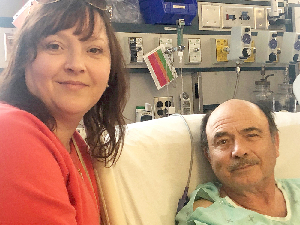 Lana Russell sits with her dad, Herb Burridge, in a Winnipeg hospital after he collapsed in the Canadian Tire parking lot on Monday. Following a public search for the person who started CPR and saved his life, it was discovered that Brandon Police Service Const. Jason Medwechuk was the life-saver. (Sumitted)