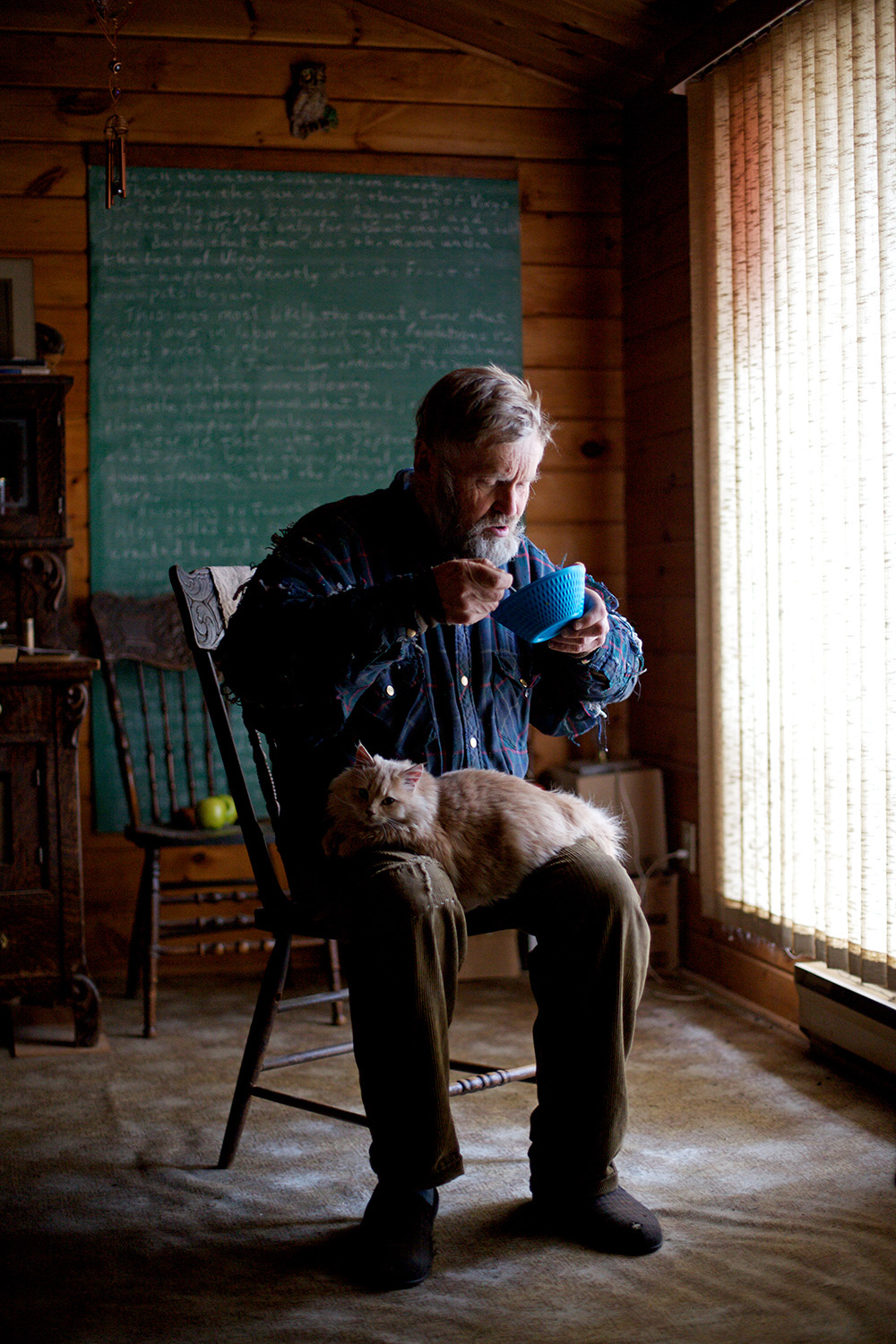 Tim Smith/Brandon Sun
Clare Haralson eats lunch by the window in the dining room of his home as Pumpkin sits on his lap in 2012. (Tim Smith/Brandon Sun)