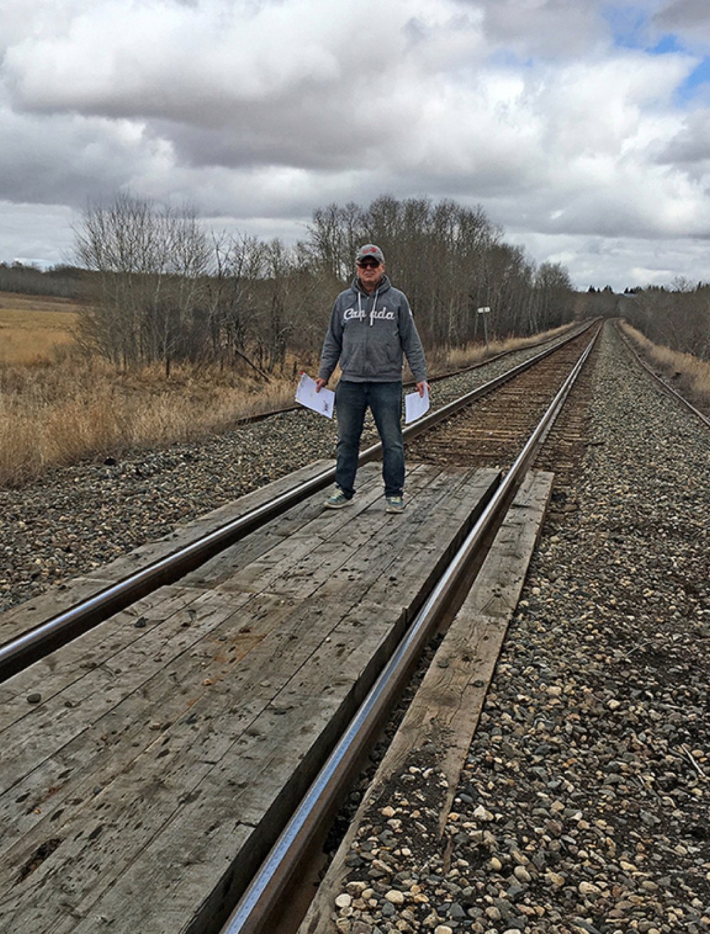 Submitted
Blane Bauer holds paperwork from CP Rail as he stands on the private rail crossing that connects his fields near Binscarth.