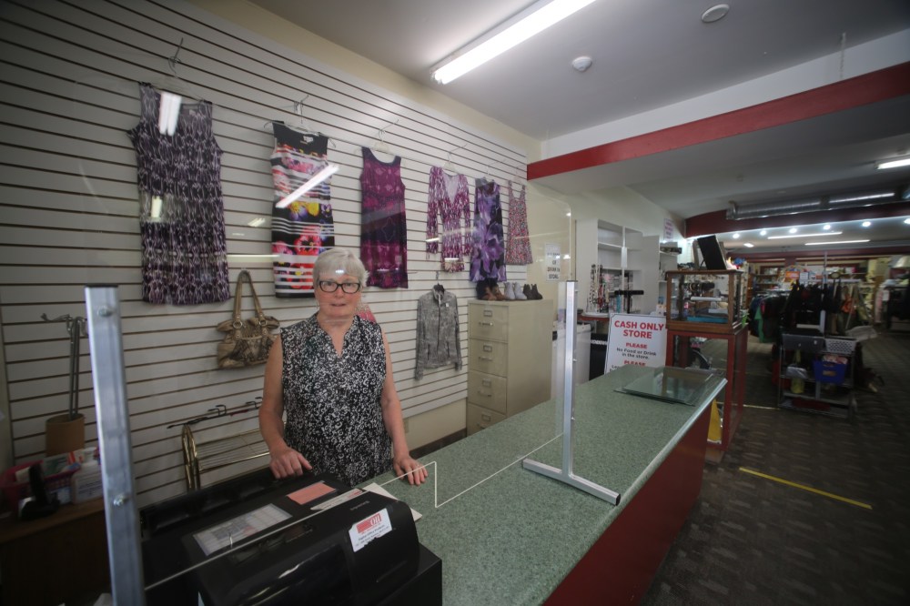 Drew May/The Brandon Sun
Keep stands behind the newly installed plexiglass shield by the shop's cash register.
