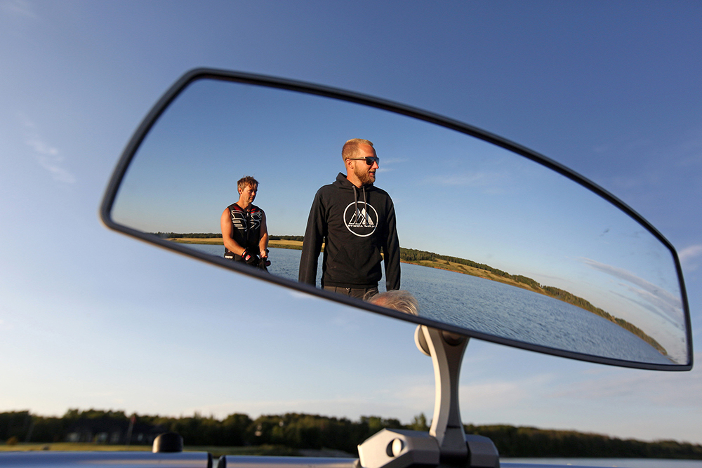 Casey Mommer and Braden Koritar are seen reflected in the mirror of a boat while out waterskiing on Lake Wahtopanah at sunrise on Tuesday morning. (Tim Smith/The Brandon Sun)