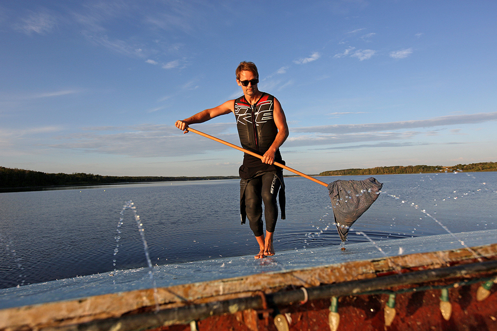Casey Mommer cleans a mess left by seagulls off the jump on Lake Wahtopanah while preparing to waterski jump on a calm and clear Tuesday morning. Mommer, an American living near Rivers, is ranked 16th in the world for waterski jumping and first in the world in the 35-plus age bracket. In a normal year he competes in a variety of international events, but due to the COVID-19 pandemic the majority of the events have been cancelled and travel is restricted. Mommer placed third in the Over-35 Men’s Jump event at the International Waterski & Wakeboard Federation Senior Worlds in Santiago, Chile, in 2018. (Tim Smith/The Brandon Sun)