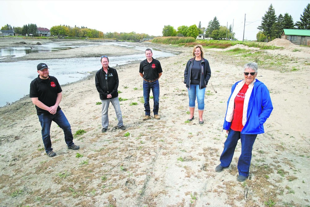 Tyler Clarke/The Brandon Sun
Rapid City community members Robert Marshall, Bob Christie, Gary Phillips, Joanne Evans and Edie Evans are seen on the community’s beach, which washed out as a result of the heavy rain event in late June. The breached dam is seen in the background.