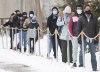 People wear face masks as they wait to be tested for COVID-19 at a clinic in Montreal, Sunday, Jan. 3, 2021. Canadian public health experts are raising alarm over an ongoing surge in COVID-19 cases and hospitalizations in several provinces. THE CANADIAN PRESS/Graham Hughes