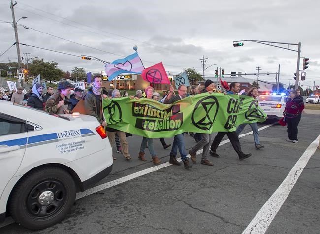 Members of Extinction Rebellion, protesting issues related to climate change, march to the Angus L. Macdonald Bridge in Dartmouth, N.S. on Monday, Oct. 7, 2019. Three people, including a climate protest organizer arrested for blocking traffic on the MacDonald Bridge in Halifax in October 2019, have each been fined a total of $237. THE CANADIAN PRESS/Andrew Vaughan