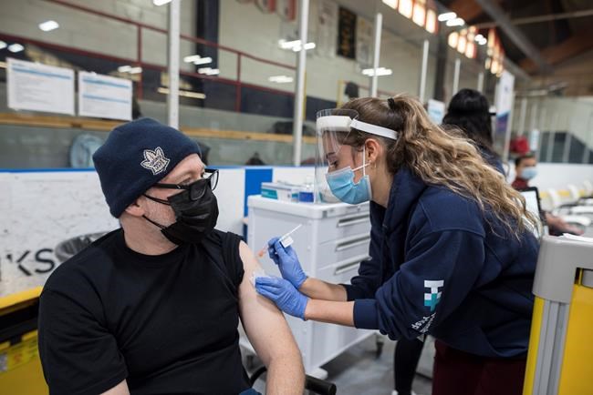 Liora Dubinsky, a nursing student for the class of 2021, administers a COVID-19 vaccine to a recipient at the Downsview Arena vaccination site, in Toronto, Friday, April 16, 2021. THE CANADIAN PRESS/Tijana Martin