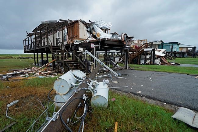 Storm clouds from approaching Tropical Storm Nicholas are seen behind homes destroyed by Hurricane Ida, in Pointe-aux-Chenes, La., Tuesday, Sept. 14, 2021. (AP Photo/Gerald Herbert)