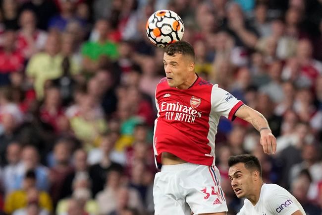 Arsenal's Granit Xhaka jumps for a header during the English Premier League soccer match between Arsenal and Tottenham Hotspur at the Emirates stadium in London, Sunday, Sept. 26, 2021. (AP Photo/Frank Augstein)