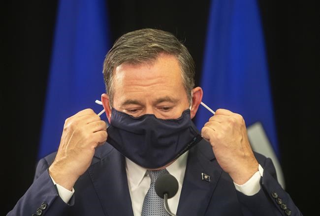 Alberta Premier Jason Kenney takes off his mask before giving a COVID-19 update in Edmonton on Sept. 21, 2021. THE CANADIAN PRESS/Jason Franson
