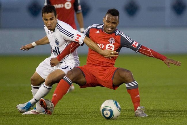Vancouver Whitecaps' Camilo da Silva Sanvezzo, left, takes down Toronto FC's Julian de Guzman during game 1 Nutrilite Canadian Championship finals soccer action in Vancouver, B.C., on Wednesday May 18, 2011. THE CANADIAN PRESS/Geoff Howe