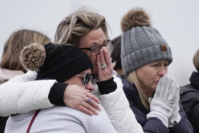 Mourners grieve at a memorial at Oxford High School in Oxford, Mich., Wednesday, Dec. 1, 2021. Authorities say a 15-year-old sophomore opened fire at Oxford High School, killing four students and wounding seven other people on Tuesday. (AP Photo/Paul Sancya)