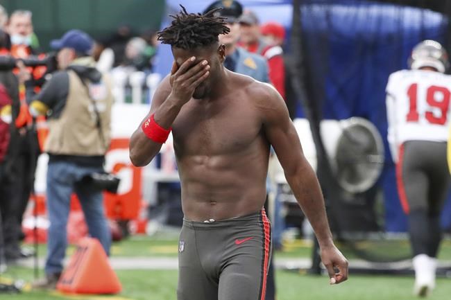 Tampa Bay Buccaneers wide receiver Antonio Brown wipes his face as he leaves the field after throwing his equipment into the stands while his team is on offense during the third quarter of an NFL football game against the New York Jets, Sunday, Jan. 2, 2022, in East Rutherford, N.J. (Andrew Mills/NJ Advance Media via AP)