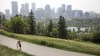 A&nbsp;pedestrian walks on a trail with the&nbsp;Calgary skyline in the background on Thursday, July 15, 2021.Once Canada's boomtown, the latest census from Statistics Canada suggests Wild Rose Country is becoming just another Canadian province. THE CANADIAN PRESS/Jeff McIntosh