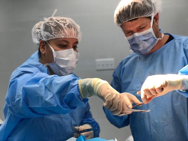Physician assistant Joanna Chan, left, assists plastic surgeon Dr. Michel Gallant, right, with the placement of a skin graft to a child's head during an operation in Port-au-Prince, Haiti, in a 2018 handout photo. Chan was part of a medical team with the organization Team Broken Earth. THE CANADIAN PRESS/HO-Team Broken Earth, *MANDATORY CREDIT*