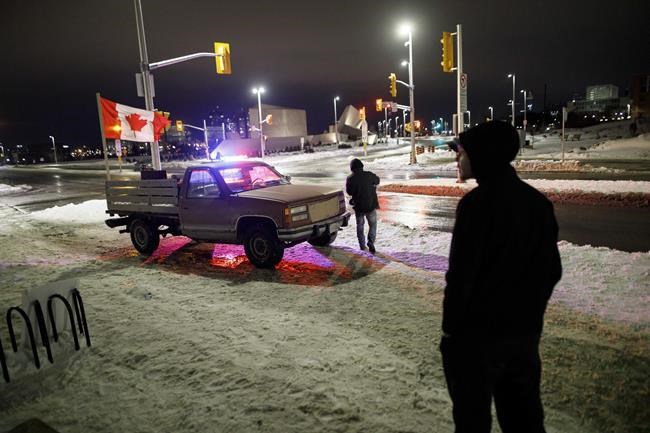 Protestors hang out on a corner on the outskirts of downtown in Ottawa, Canada, on Monday, Feb. 21, 2022, after officers worked to clear a trucker protest that was aimed at COVID-19 measures before growing into a broader anti-government protest that occupied the nation capitalÕs downtown core. THE CANADIAN PRESS/Cole Burston