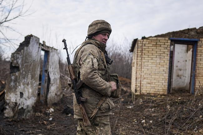A Ukrainian serviceman stands at his position at the line of separation between Ukraine-held territory and rebel-held territory near Svitlodarsk, eastern Ukraine, Wednesday, Feb. 23, 2022. U.S. President Joe Biden announced the U.S. was ordering heavy financial sanctions against Russia, declaring that Moscow had flagrantly violated international law in what he called the