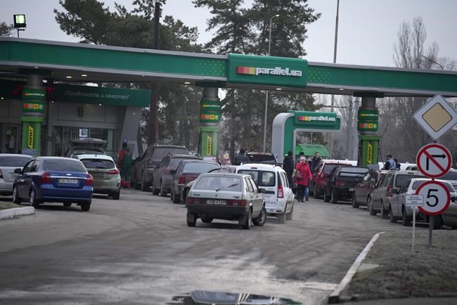 People queue for fuel at a gas station in Sievierodonetsk, the Luhansk region, eastern Ukraine, Thursday, Feb. 24, 2022. Russian President Vladimir Putin on Thursday announced a military operation in Ukraine and warned other countries that any attempt to interfere with the Russian action would lead to
