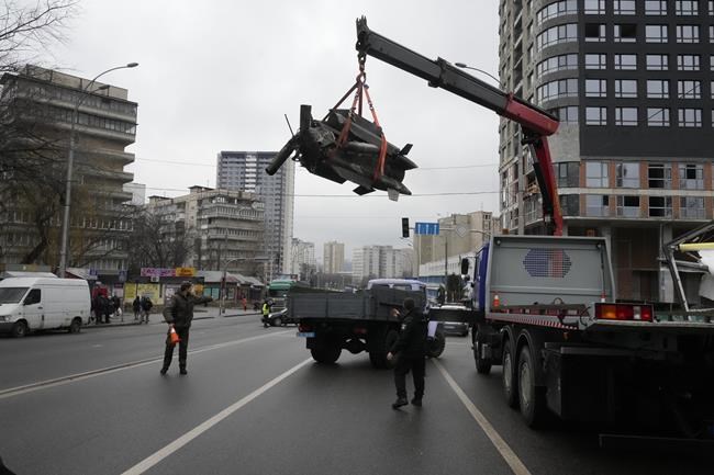 Workers load the debris of a rocket onto a truck the aftermath of Russian shelling in Kyiv, Ukraine, Thursday, Feb. 24, 2022. Russian troops have launched their anticipated attack on Ukraine. Big explosions were heard before dawn in Kyiv, Kharkiv and Odesa as world leaders decried the start of an Russian invasion that could cause massive casualties and topple Ukraine's democratically elected government. (AP Photo/Efrem Lukatsky)
