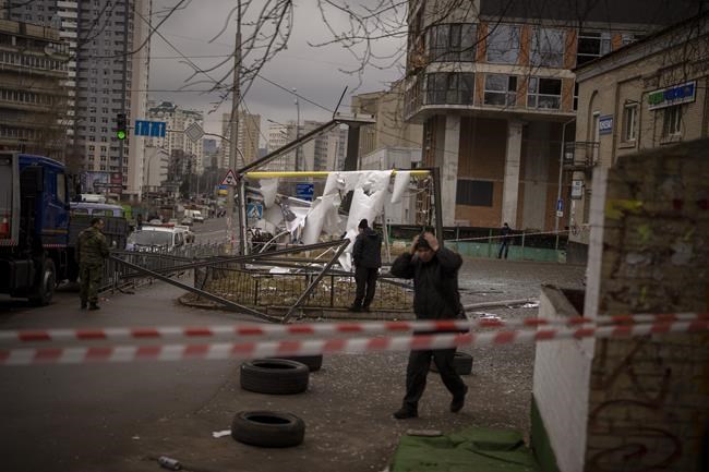 Police officers inspect area after an apparent Russian strike in Kyiv Ukraine, Thursday, Feb. 24, 2022. Russian President Vladimir Putin on Thursday announced a military operation in Ukraine and warned other countries that any attempt to interfere with the Russian action would lead to