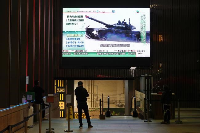 A man watches a huge TV screen broadcasting the news of Russian troops that have launched their attack on Ukraine, in Hong Kong Thursday, Feb. 24, 2022. Russian troops launched their anticipated attack on Ukraine on Thursday, as President Vladimir Putin cast aside international condemnation and sanctions, warning other countries that any attempt to interfere would lead to